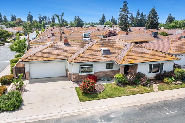 943 E Goshen Ave, Fresno, CA 93720 - view of front of house with a tiled roof, stucco siding, an attached garage, driveway, and a residential view