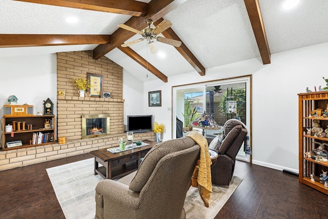 living area featuring dark wood-style flooring, ceiling fan, a brick fireplace, baseboards, and vaulted ceiling with beams