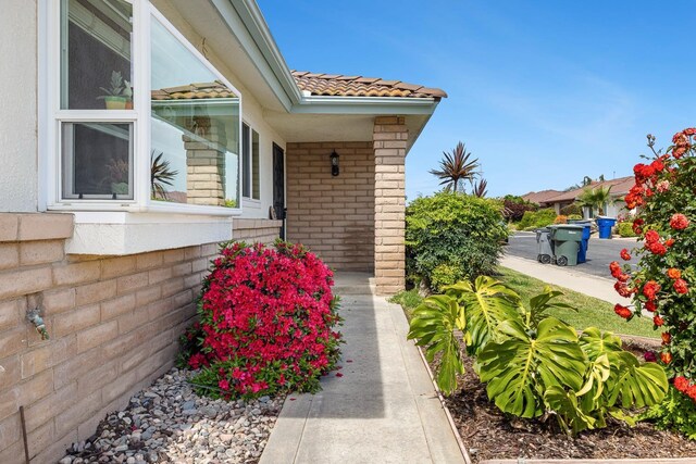 943 E Goshen Ave, Fresno, CA 93720 - property entrance with a tiled roof, covered porch, and brick siding