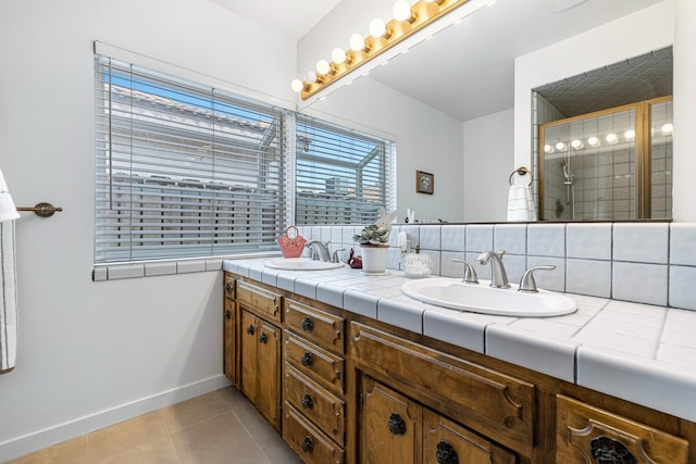 bathroom with baseboards, a sink, tile patterned flooring, and double vanity