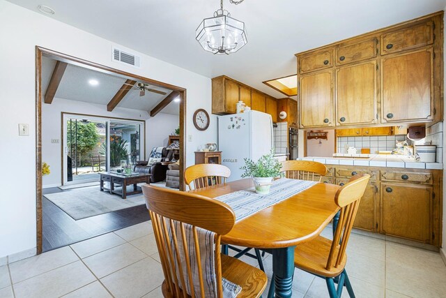 943 E Goshen Ave, Fresno, CA 93720 - dining space featuring beamed ceiling, light tile patterned flooring, a chandelier, and ceiling fan
