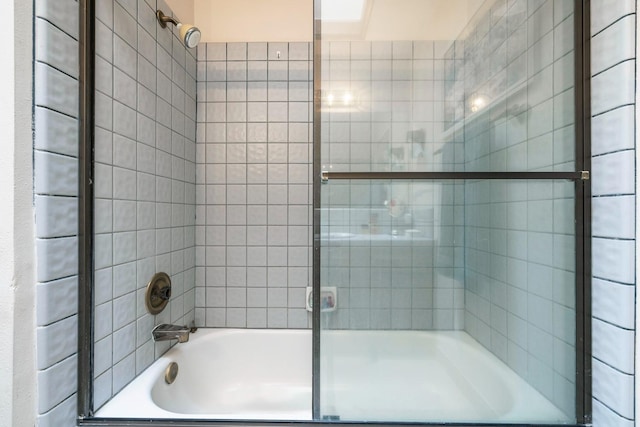 bathroom featuring combined bath / shower with glass door