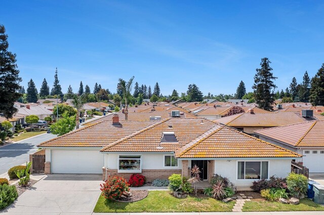943 E Goshen Ave, Fresno, CA 93720 - view of front of home featuring stucco siding, a tile roof, concrete driveway, a garage, and a residential view