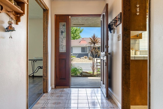 entryway featuring baseboards and light tile patterned floors