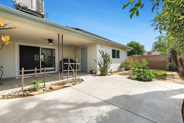 exterior space featuring fence, a patio area, and stucco siding