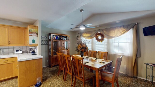 dining room featuring ceiling fan, baseboards, and lofted ceiling