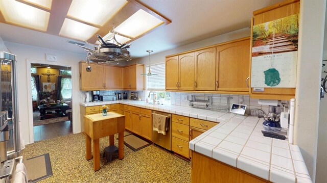 kitchen with decorative backsplash, a sink, and dishwasher