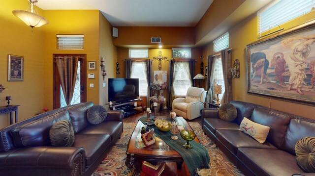 living area with visible vents and wood finished floors