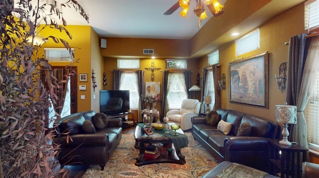 living area featuring visible vents, a ceiling fan, wood finished floors, and a wealth of natural light