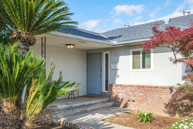 6352 N Fisher St, Fresno, CA 93710 - doorway to property featuring stucco siding, brick siding, and a shingled roof