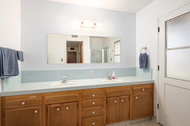6352 N Fisher St, Fresno, CA 93710 - full bathroom featuring double vanity, a shower stall, and decorative backsplash