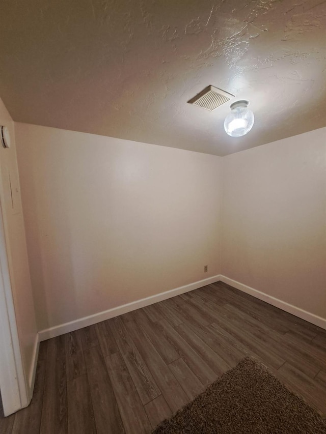 unfurnished room with visible vents, baseboards, and wood finished floors