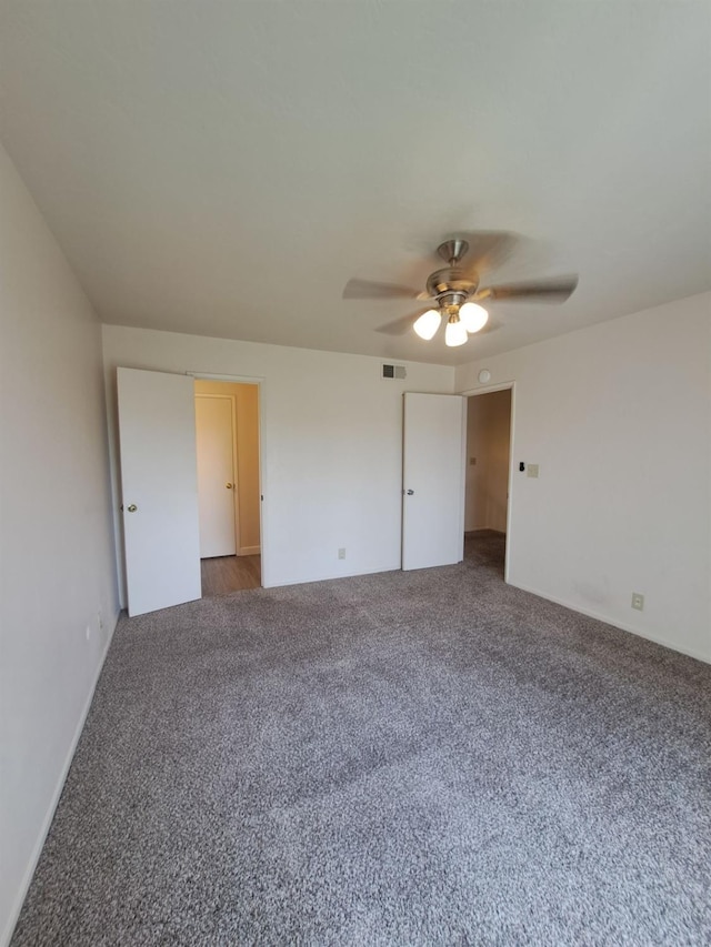 unfurnished bedroom with carpet floors, ceiling fan, and visible vents