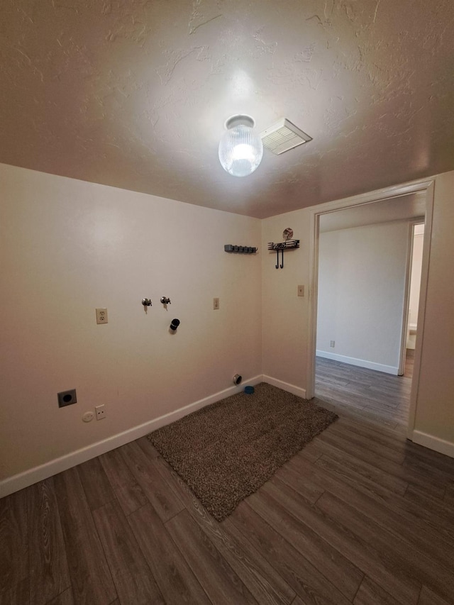 interior space featuring a textured ceiling, hookup for an electric dryer, laundry area, and wood finished floors