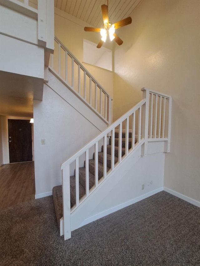 stairs with wooden ceiling, ceiling fan, baseboards, and carpet flooring