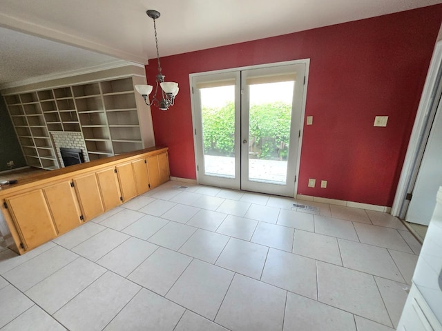 unfurnished dining area featuring light tile patterned flooring, baseboards, a notable chandelier, and built in features