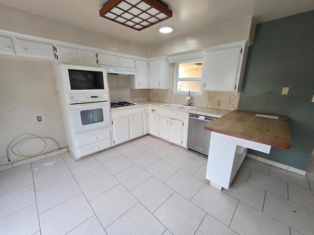 kitchen featuring decorative backsplash, a sink, white oven, and dishwasher