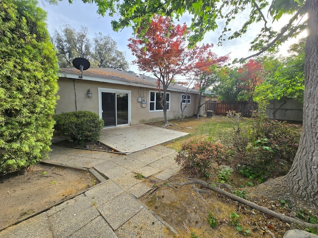 back of property with a patio, fence, and stucco siding