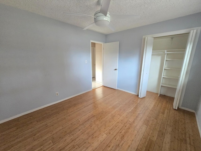 unfurnished bedroom featuring baseboards, light wood-style flooring, a ceiling fan, and a textured ceiling