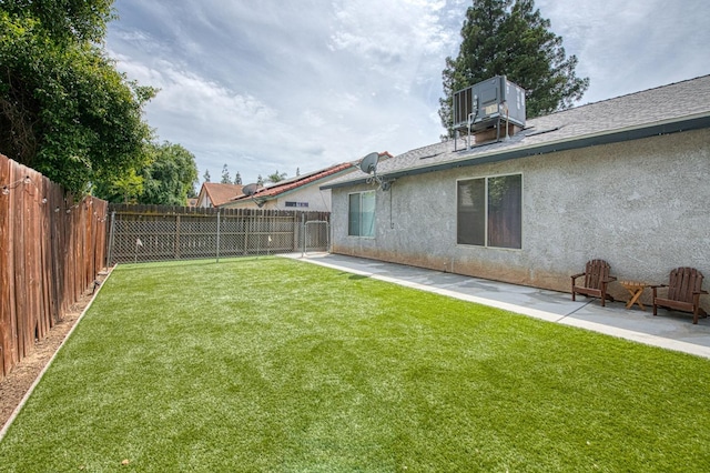 view of yard with a patio, a fenced backyard, and central air condition unit