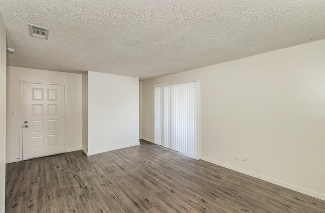 1221 N Peach Ave Unit 226, Fresno, CA 93727 - unfurnished room featuring baseboards, dark wood-style flooring, a textured ceiling, and visible vents
