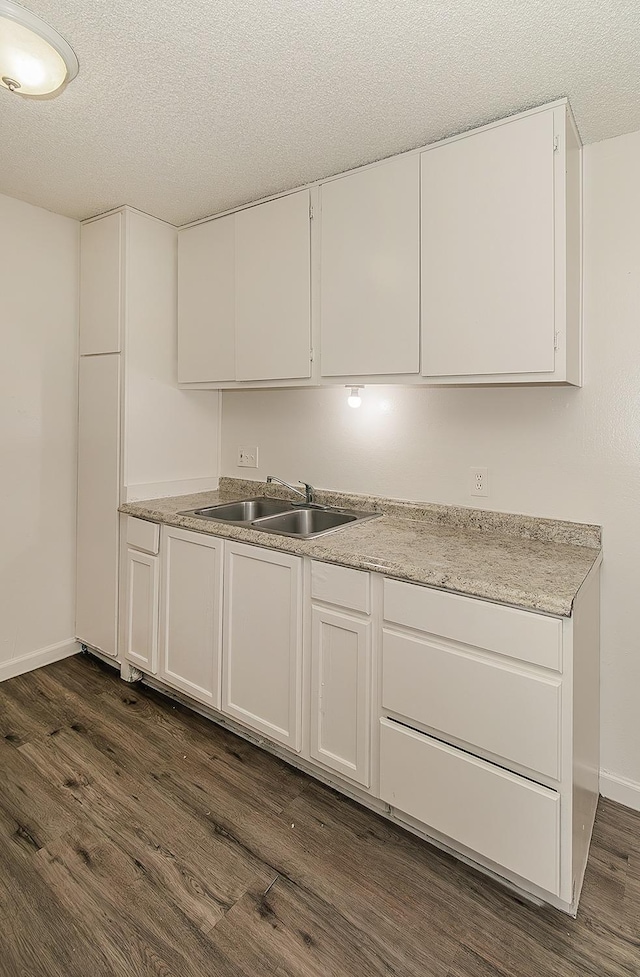 1221 N Peach Ave Unit 226, Fresno, CA 93727 - kitchen with a textured ceiling, a sink, light countertops, dark wood-style floors, and white cabinetry