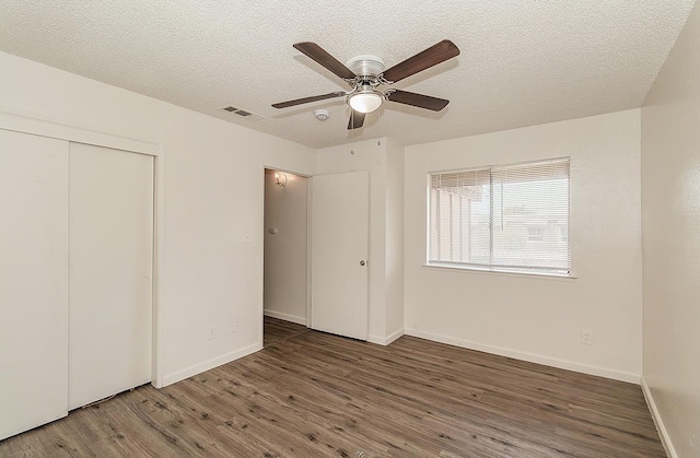 1221 N Peach Ave Unit 226, Fresno, CA 93727 - unfurnished bedroom featuring a textured ceiling, visible vents, wood finished floors, baseboards, and a closet