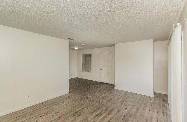 1221 N Peach Ave Unit 226, Fresno, CA 93727 - unfurnished room featuring visible vents, baseboards, a textured ceiling, and wood finished floors