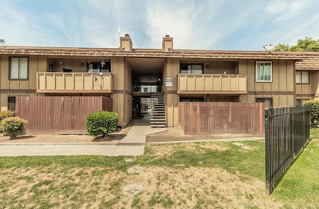 1221 N Peach Ave Unit 226, Fresno, CA 93727 - view of front of house with board and batten siding, fence, stairs, and a front yard