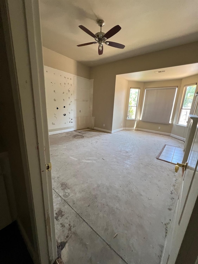 unfurnished room with baseboards and ceiling fan