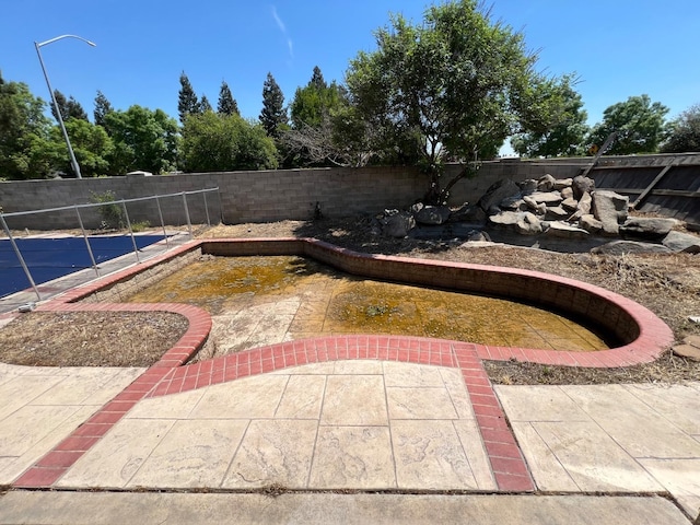 view of pool with a fenced backyard and a patio