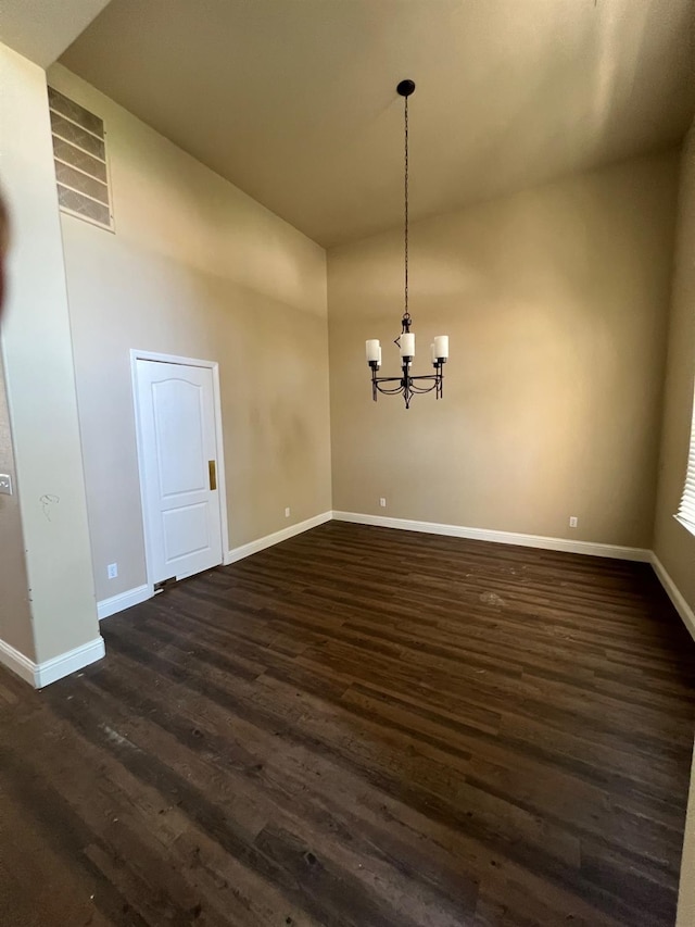 unfurnished dining area featuring visible vents, baseboards, high vaulted ceiling, dark wood-style floors, and a notable chandelier