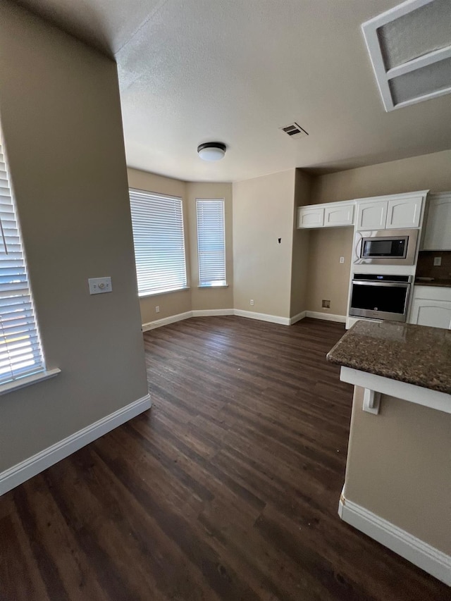 kitchen with stainless steel appliances, visible vents, white cabinetry, and a wealth of natural light