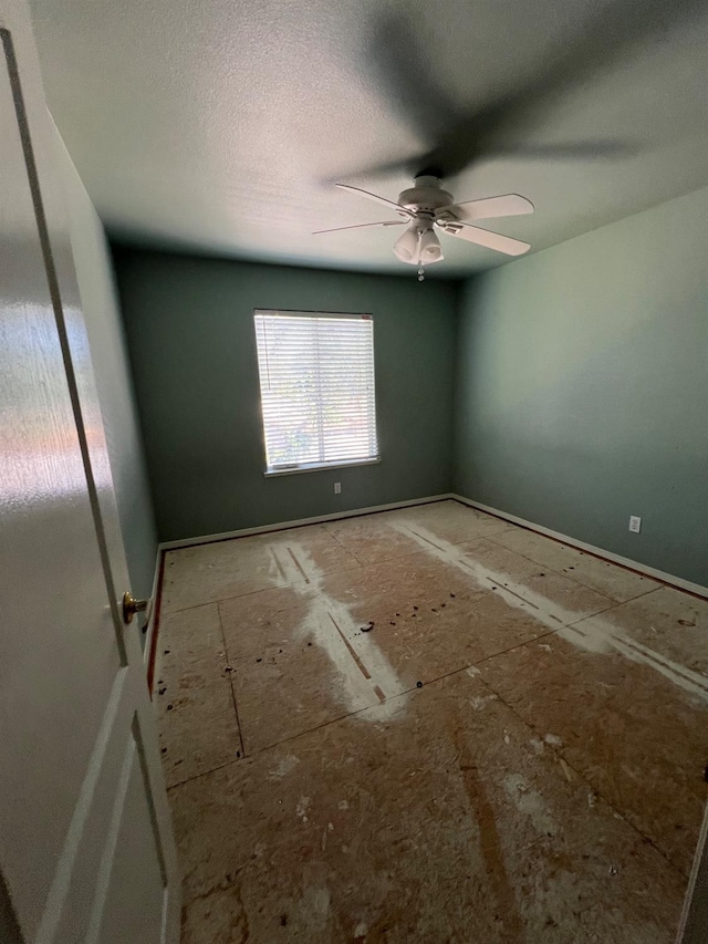 unfurnished room featuring baseboards and ceiling fan