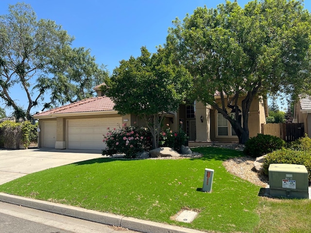 view of front of home featuring a front lawn, stucco siding, a tiled roof, concrete driveway, and an attached garage