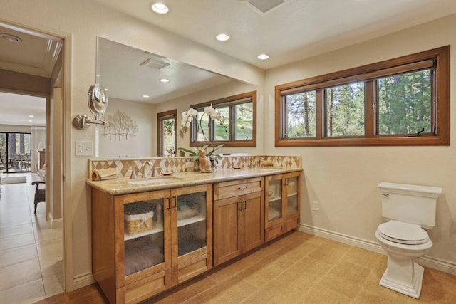 bathroom featuring recessed lighting, baseboards, and a sink