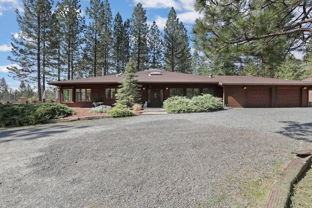 view of front facade featuring an attached garage and gravel driveway