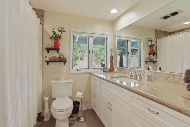 bathroom featuring vanity, baseboards, and toilet