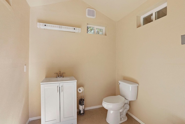 half bathroom with visible vents, vanity, toilet, baseboards, and vaulted ceiling
