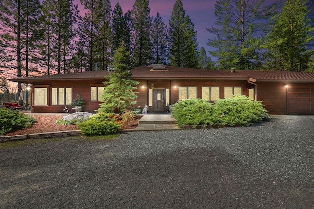view of front of house with a garage and gravel driveway