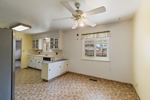 kitchen featuring visible vents, light countertops, a peninsula, glass insert cabinets, and white cabinetry