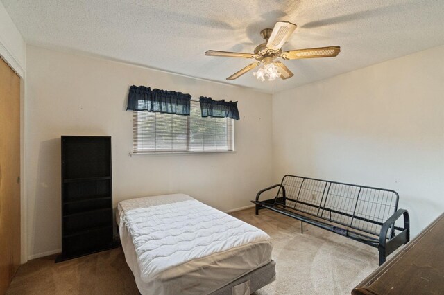 carpeted bedroom featuring a ceiling fan, baseboards, and a textured ceiling