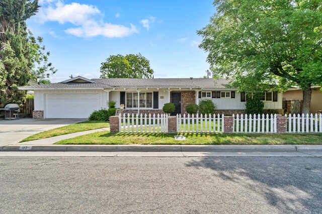 ranch-style home featuring brick siding, driveway, a fenced front yard, and a garage