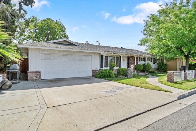 ranch-style home featuring a garage, fence, driveway, and brick siding