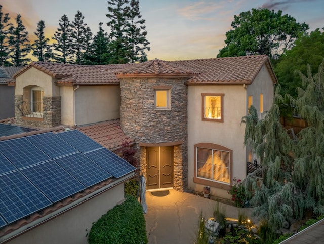 9596 N Winery Ave, Fresno, CA 93720 - view of front of home with stucco siding, solar panels, a tiled roof, and stone siding