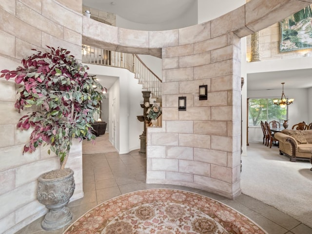 9596 N Winery Ave, Fresno, CA 93720 - foyer entrance featuring carpet floors, stairs, a towering ceiling, tile patterned floors, and a chandelier