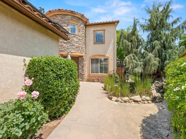 9596 N Winery Ave, Fresno, CA 93720 - entrance to property featuring fence, a patio area, stone siding, and stucco siding
