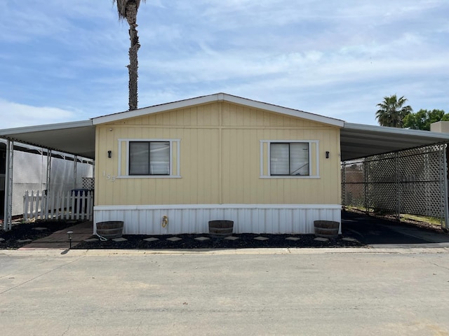 860 E Grangeville Blvd Unit 153, Hanford, CA 93230 - view of property exterior featuring an attached carport and asphalt driveway
