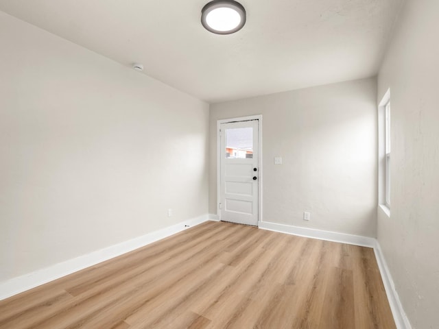 unfurnished room with baseboards and light wood finished floors