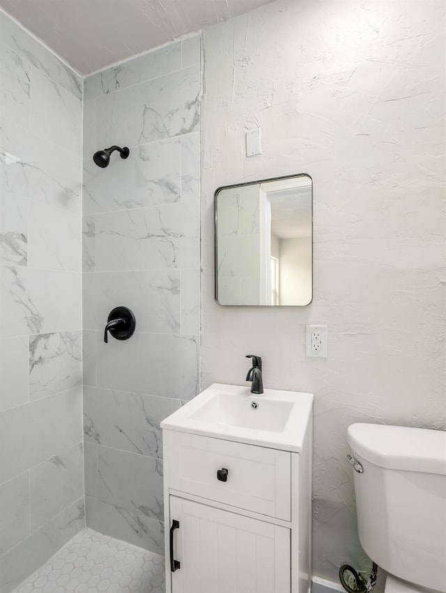 full bath with a stall shower, toilet, and vanity
